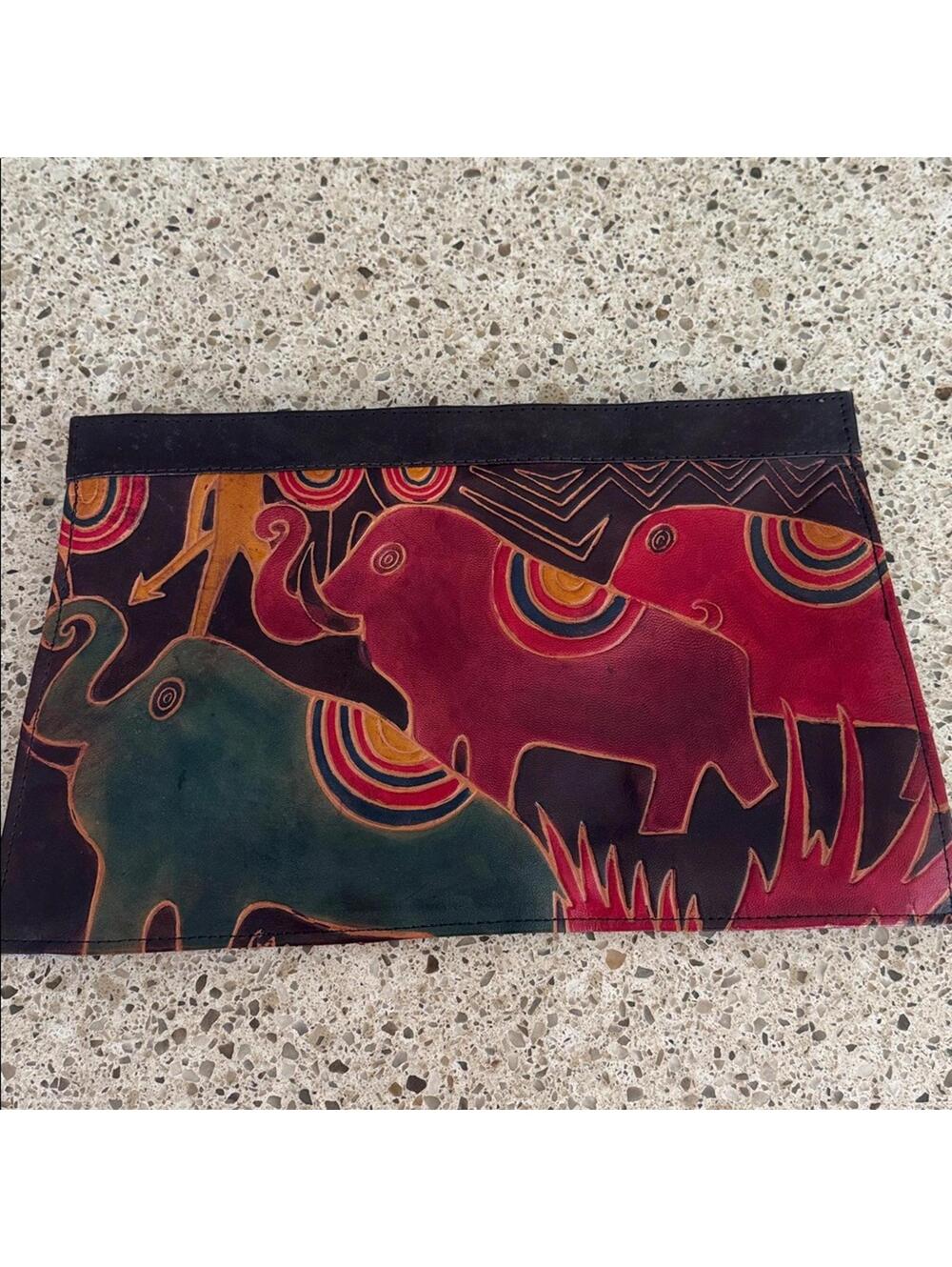Leather hand crafted clutch purse with colorful elephants.